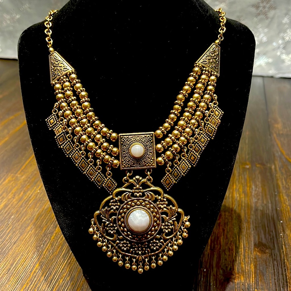 Bohemian styled gold color necklace with two white marble like accents